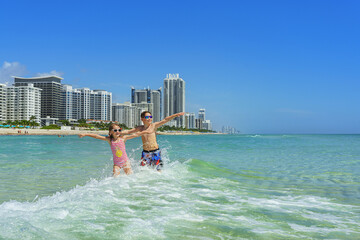 Family joy in a holiday - Miami Beach. Happy moments in the clean  water.