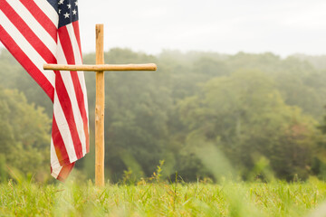 a cross and american flag in a field