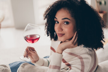 Photo portrait of attractive young woman sit sofa hold drink wine glass dressed casual clothes cozy...