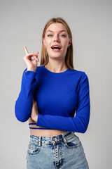 Young Woman Gesturing With Her Finger While Speaking Against a Gray Background - 788452769