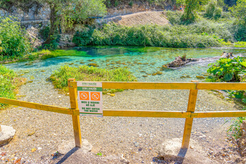 Turquoise and green water lake protection fence at blue eye lake spring water in blue eye- Albania.