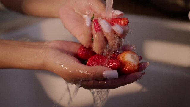 Eating strawberries, washing and preparing vegetables in the kitchen