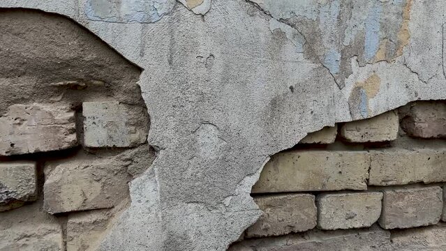Background of a crumbling brick wall close-up. The texture of a crumbling wall