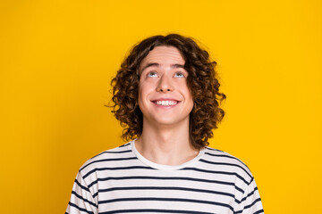 Close up photo of young optimistic teenage guy curly hair looking up billboard offer announcement...