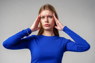 Woman in Blue Top Holding Hands to Ears in studio