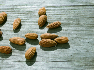 Almond nuts on grey wooden table background. Almond nuts on a wooden desk