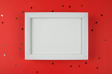 white wooden photo frame on a red background with guitar.
