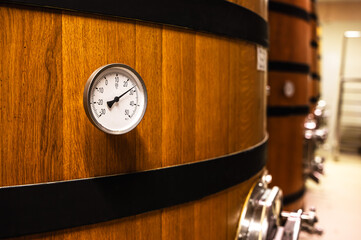 Close up oak wood barrel with controlling tool for winery quality in wine industry factory