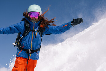 Woman snowboarder riding on slope of powdery snow in high mountains. Freeride at ski resort,...