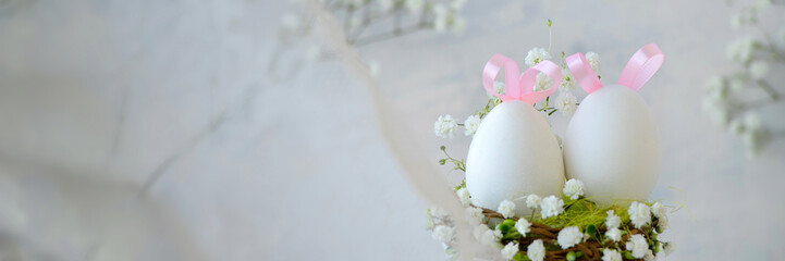 banner of white Easter eggs with pink bunny ears in a nest with white small flowers through a lace curtain. Easter background or postcard