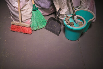 Broom, dust pan , bucket and mop, and trash bags garbage on the dirty dusty floor. Cleaning concept.