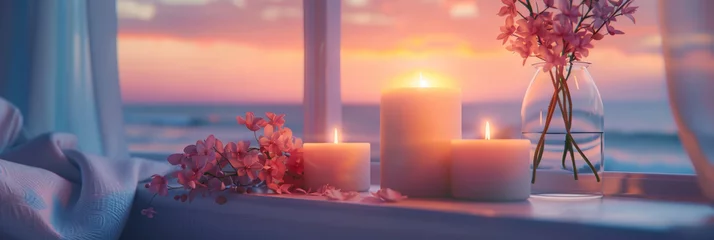Poster Candles and scented candles on the bedside table, white sheets, pink flowers in vases, and window views of sea waves at sunset.  warm ambiance for romantic moments or peaceful sleep.  © Nice Seven
