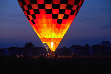 Ballooning festival on balloons preparation for flights, installation of balloon equipment, pilots set up a balloon in the field at night.