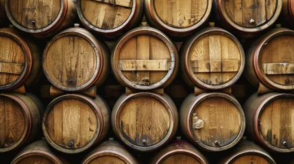 Fotobehang Rows of wooden wine barrels stacked high, creating a picturesque background © Sasint