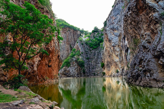 Beautiful nature scenic landscape with mountain range and beautiful hidden spot in Khao Ngu Stone Park at Ratchaburi, Thailand. Landscape view of mountain cliffs In green canyon lake. Amazing nature.