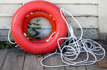 two orange life preservers and a rope lying on a dock