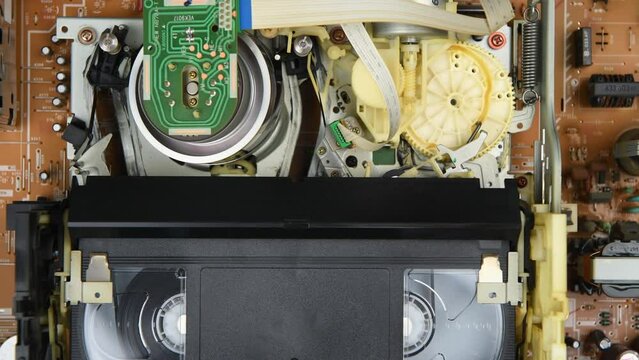 Insert the video VHS cassettes into the VCR, play and rewind and eject cassettes in 4K. Top view.