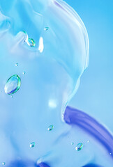 Gel texture of cosmetic products. transparent cream on a blue background with bubbles. macro photo. blur and selective focus.
