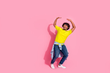 Photo of funny cheerful man wear stylish yellow clothes hold huge heavy banner empty space isolated on pink color background