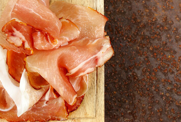 prosciutto ham on a wooden board with basil - 788519540