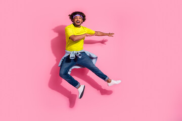 Photo of overjoyed nice man wear stylish yellow clothes have fun jump up isolated on pink color...