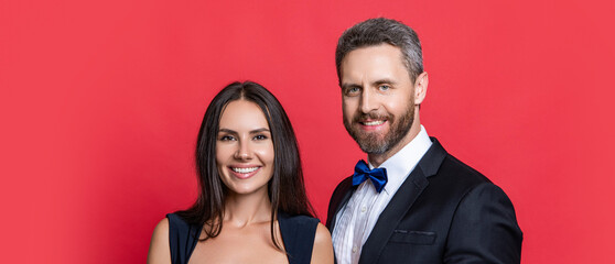Couple is posing. Elegant couple in formal clothes isolated on red. Woman and man at occasion date. Romantic love. Valentines day. Elegantly dressed couple. Formal man and woman