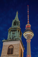 The famous TV Tower and the tower of St. Mary's Church at the Alexanderplatz in Berlin at night - 788535947