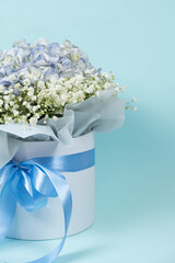 Bouquet of flowers made of hydrangeas and gypsophila in a white box with a bow