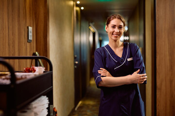 Portrait of happy hotel housekeeper with her arms crossed looking at camera.
