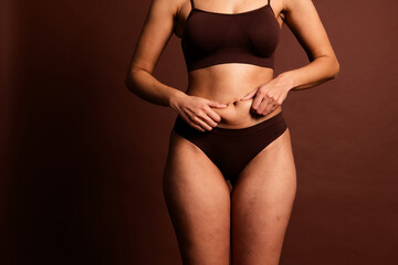 Cropped photo of pretty fatty lady underwear enjoying stomach massage isolated brown color...