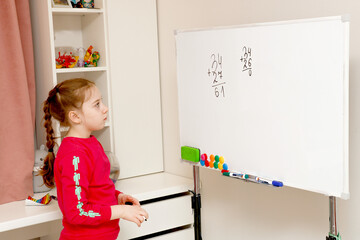 back to school, girl solves house example on blackboard