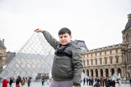 tourist kid posing in front of the Louvre  Paris
