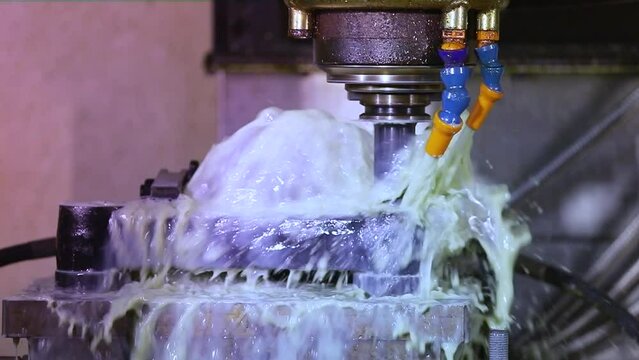 CNC grinding milling machine. CNC turning center. CNC machining high precision turning throwing coolant liquid on metal component during shaping forming process using machining center rotating cutting