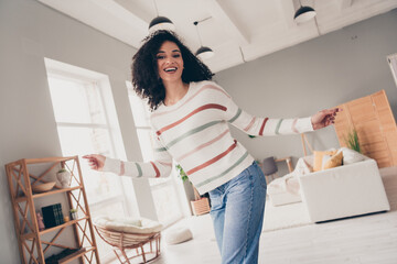 Photo of adorable carefree lady dressed striped pullover having fun indoors apartment room