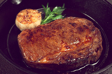 grilled rib eye steak, in a cast-iron skillet, top view, homemade, no people,