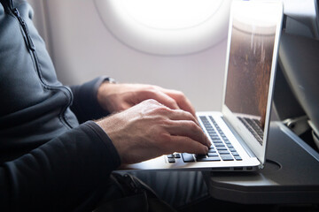 man working on a laptop during flight