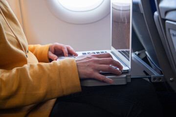 woman working on a laptop during flight