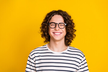 Close up photo of young nice mood attractive cheerful teenager in casual t shirt toothy beaming smile isolated on yellow color background