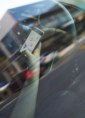 Person, car and hand with map on smartphone for direction, route and navigate city as tourist....