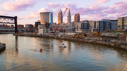Naklejka premium City skyline at sunset with boaters and construction in the foreground