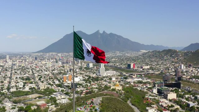 Aerial Backward Shot Of Tall Flag At Mirador Del Obispado On Hill In City Against Sky - Monterrey, Mexico