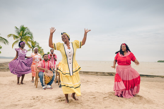 Two beautiful black girls dancing on the beach to the rhythm of Garífuna music.