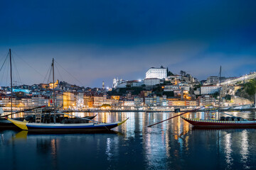 Porto, Portugal old town on the Douro River with traditional rabelo boats at night. With wine barrels from the port on the Douro River, Ribeira I in the background, Porto, Portugal. - 788576540