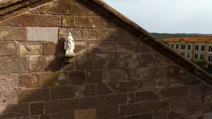 Aerial view of a small statue of Mary, the mother of Jesus. This statue is located on the facade of...