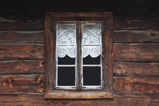 Wooden rustic window in cottage house. Lace curtains glass window home. Rusty architecture. Podlasie region in Poland vintage wall. Wood home wall facade. Village farm building. - Powered by Adobe