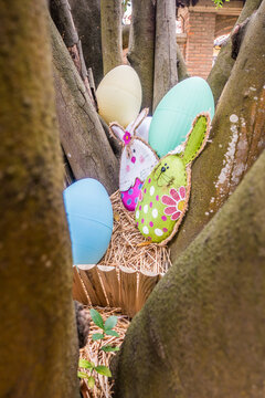 Easter eggs painted like rabbits between the trunks of a tree