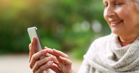 Park, happy and senior woman with smartphone, typing and online communication with technology in...