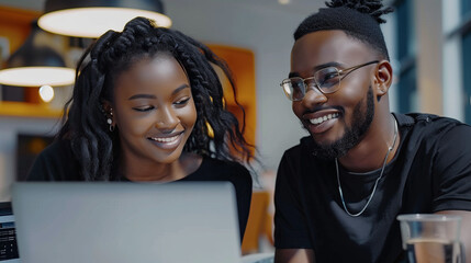 young handsome black man and young beautiful black woman working at the office front of the laptop computer