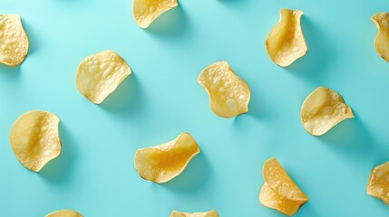 Crispy potato chips arranged on a blue background. Perfect for food and snack related projects - obrazy, fototapety, plakaty