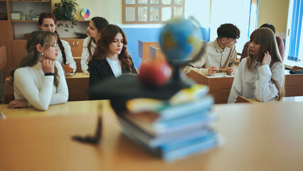 A globe of the world in a school classroom during a lesson in front of a globe of books.